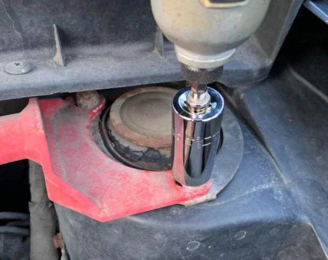 Power drill with socket attachment tightening bolt on car strut mount